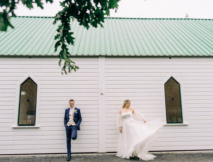 Real wedding couple leaning against Little White Chapel